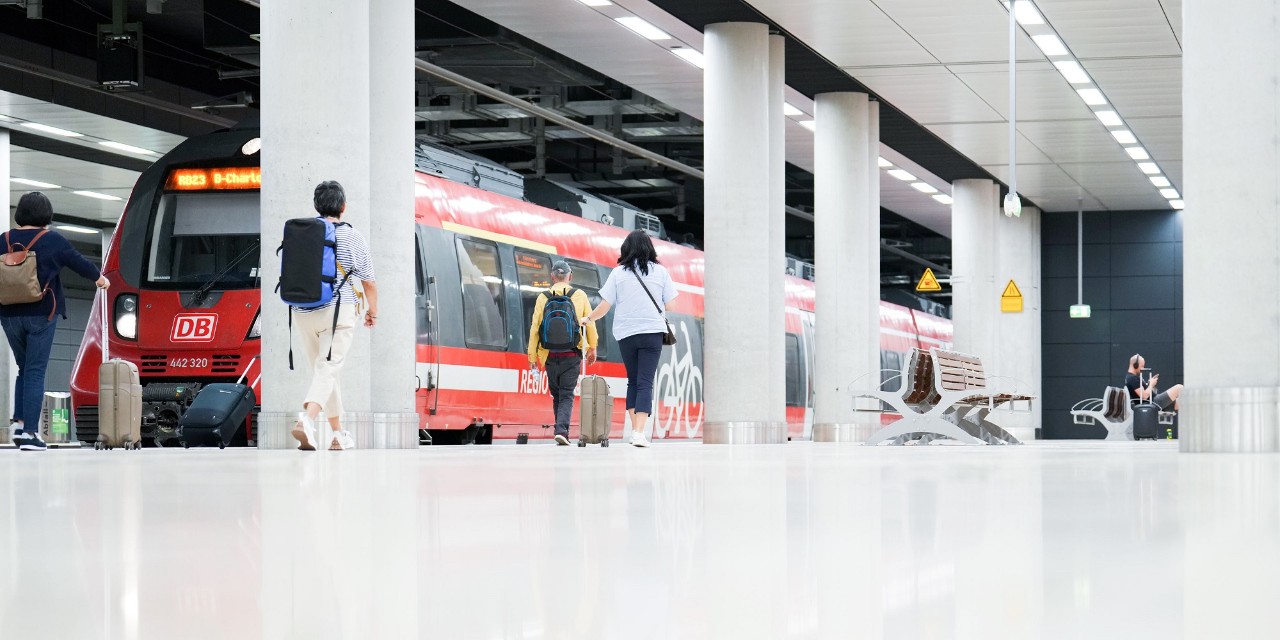 Railway station under Terminal 1 of BER . People walking to a regional train.