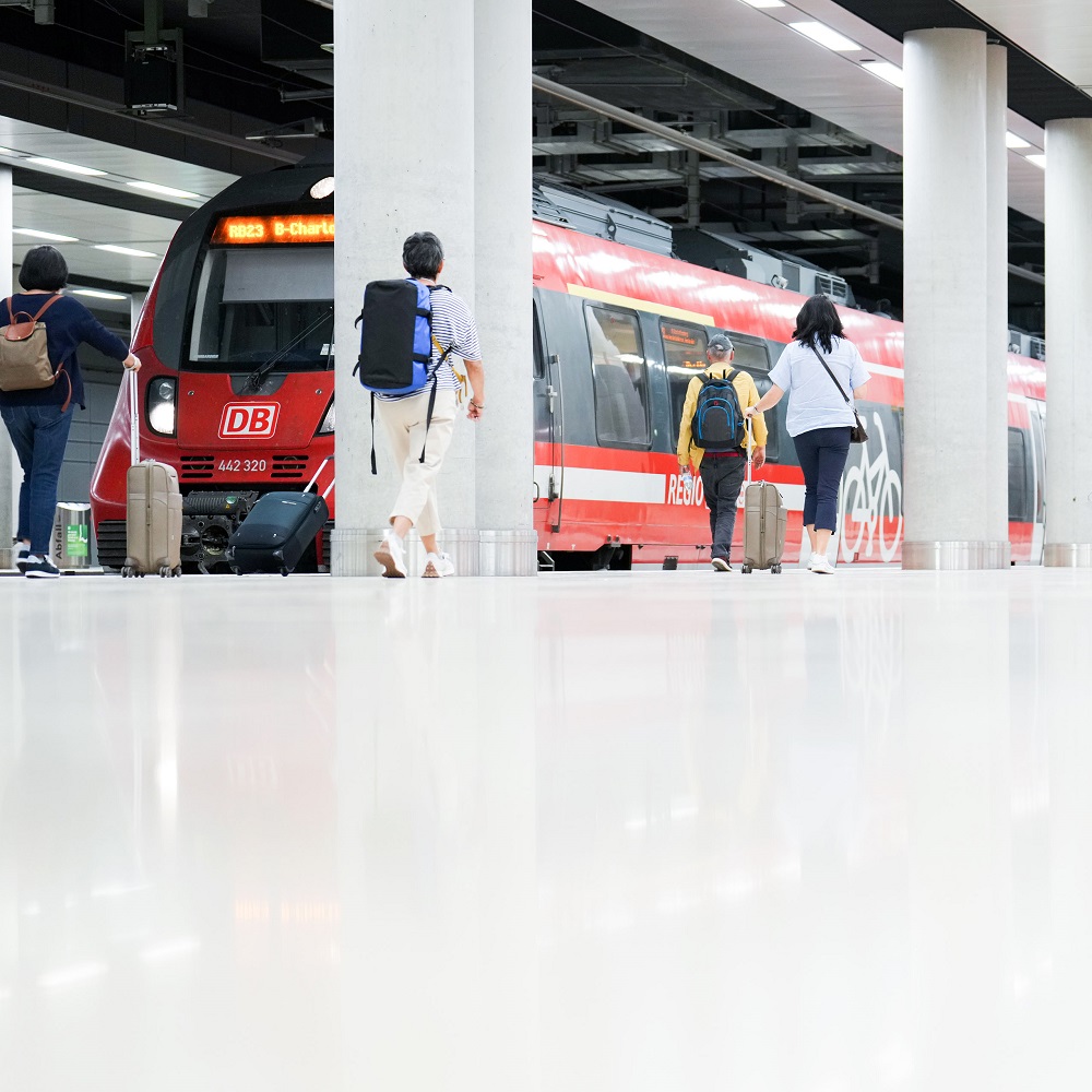 Railway station under Terminal 1 of BER . People walking to a regional train.