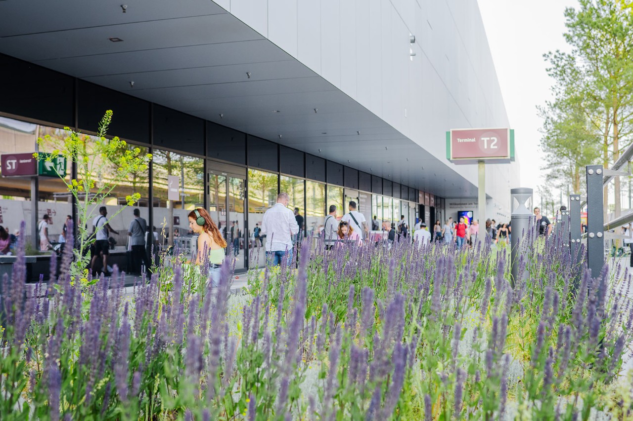 View of Terminal 2 from outside in front of flowers.