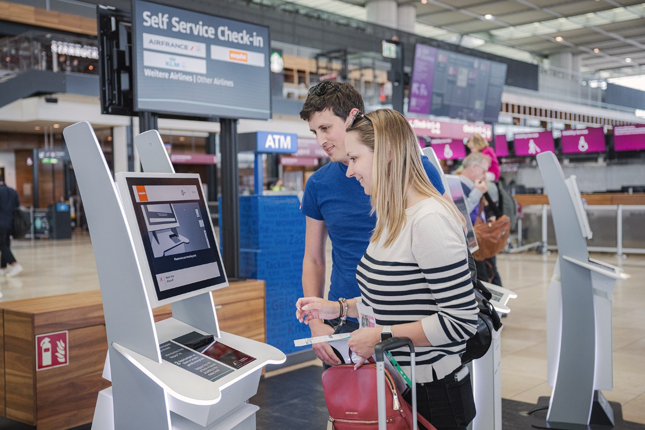 Passengers at Fast Bag Drop kiosks