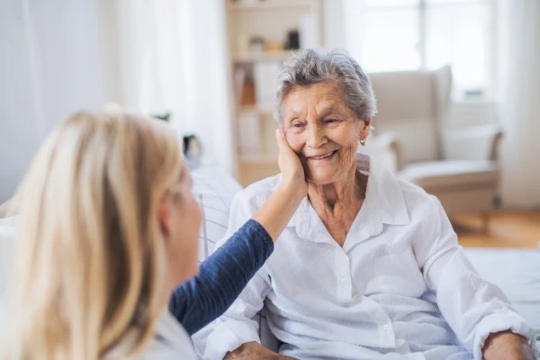 A young woman comforting an elderly one