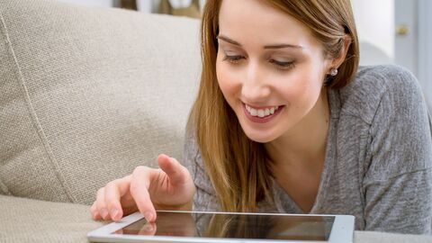 Frau mit Tablet auf Sofa