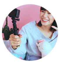 Woman smiling using a selfie stick.