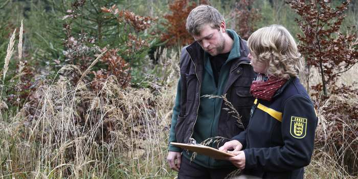 Eine Mitarbeiterin einer forstlichen Behörde berät einen Waldbesitzer; Bild ForstBW