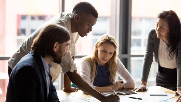 Photo of a team of four people talking in a small group.