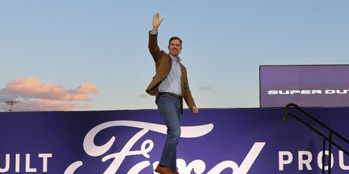 Governor Andy Beshear waves from on stage