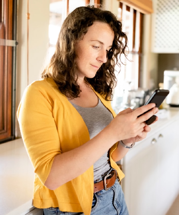 A woman looks at her phone while learning about Facebook Marketplace scams.