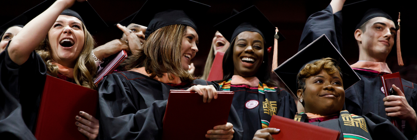 A group of students in caps and gowns celebrating their graduation