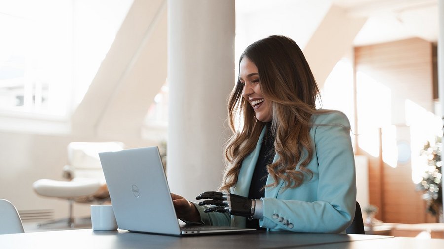 Frau arbeitet produktiv am Laptop und lacht