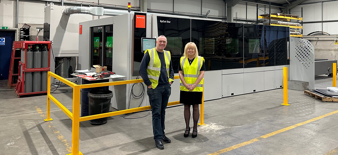 Photo of 2 people standing in an engineering factory