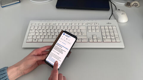 Eine Person schaut sich die Datenschutz-Hinweise des RP auf dem Smartphone an