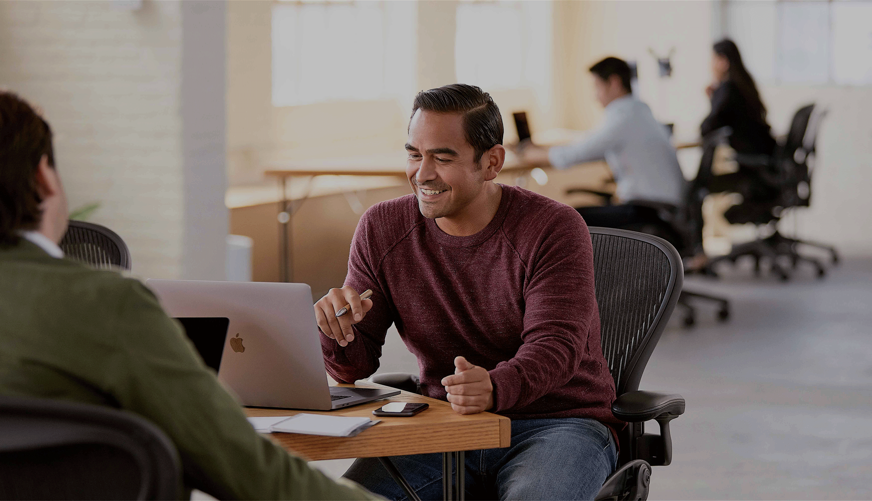 A team of two people working together at a desk. 