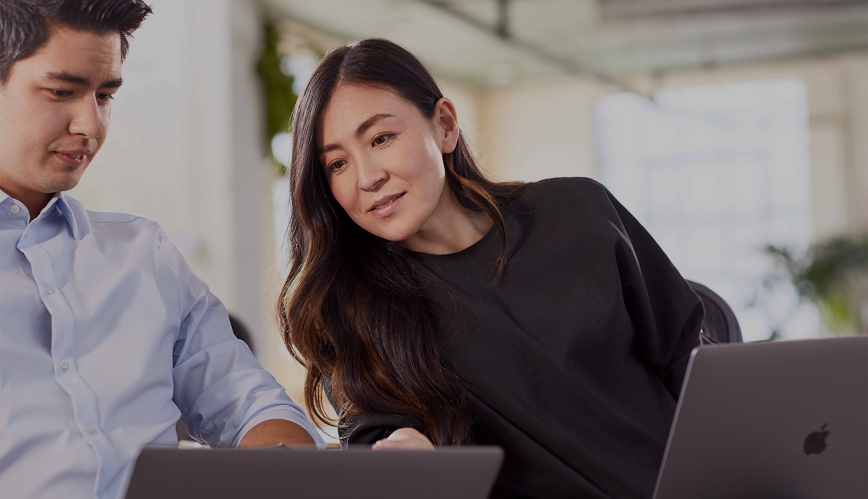 A team of two people working together on computers.