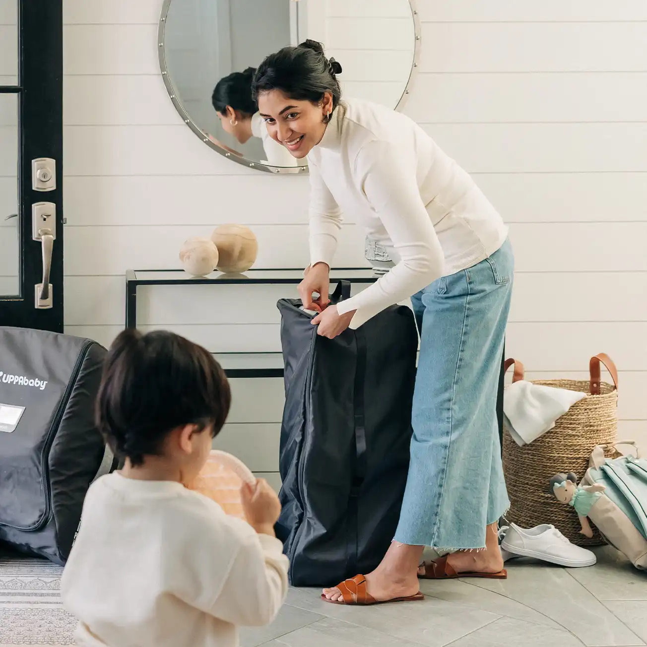 While her child plays, a woman effortlessly begins to set up her lightweight Remi, removing it from the included storage bag