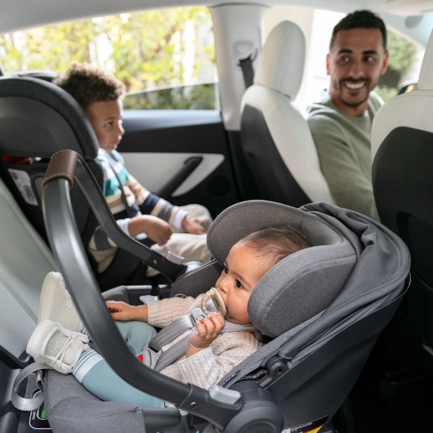 The Aria car seat installed next to a convertible car seat, thanks to Aria's narrow 17 inch wide footprint