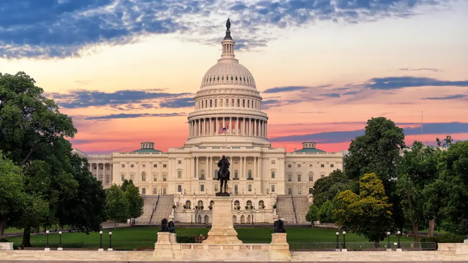 United States Capitol and ground with pink and orange sky at sunset