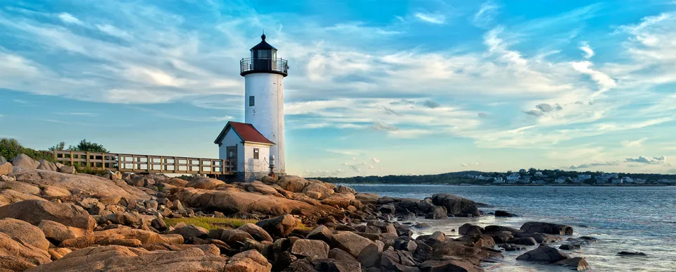 Old lighthouse along a rocky Massachusetts shoreline at low tide