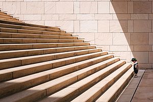 Kind steht vor einer langen Treppe