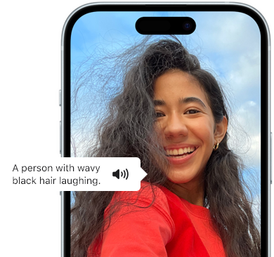 iPhone 15 displaying a VoiceOver announcement describing a photograph as: a person with wavy black hair laughing