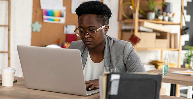 Female professor works on an article using her laptop.