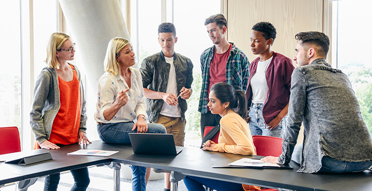 Professor explains difficult concept to group of diverse students.