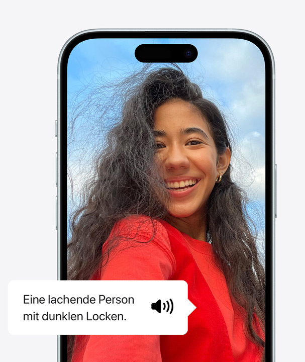 A picture of an iPhone using VoiceOver to describe the details of a person on screen laughing with wavy hair.