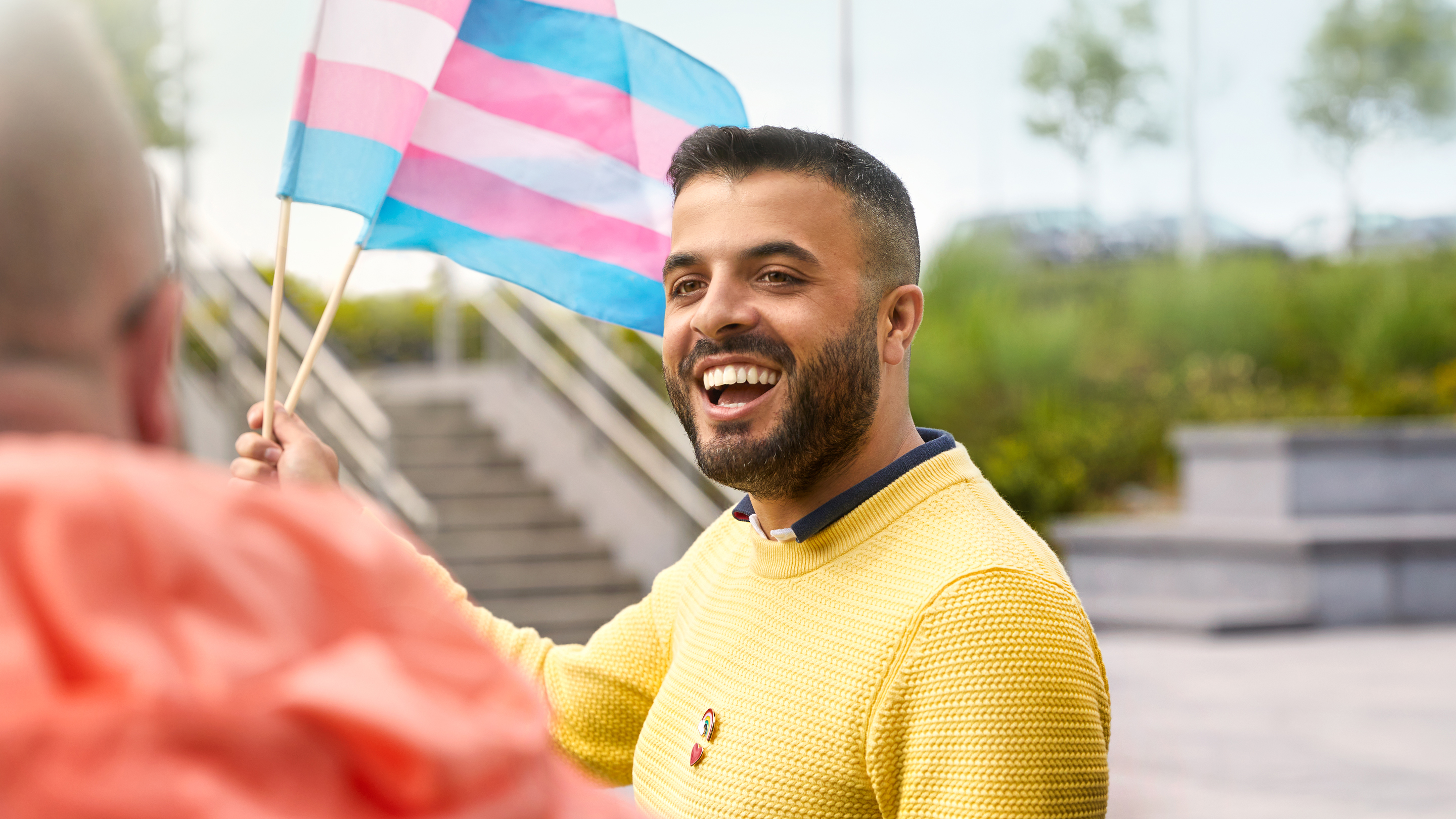 Medewerker van Apple Cork die met een transgendervlag zwaait.