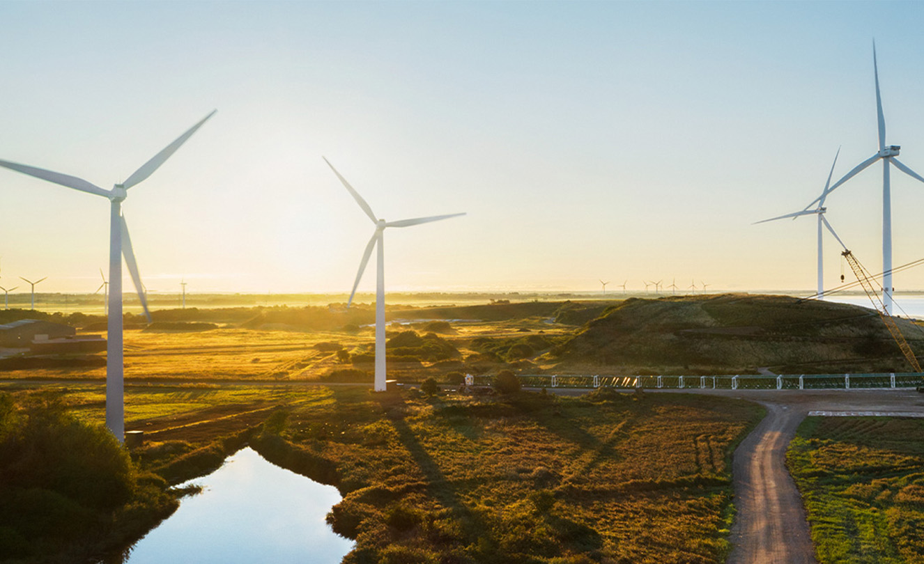 A field dotted with several energy-producing wind turbines.