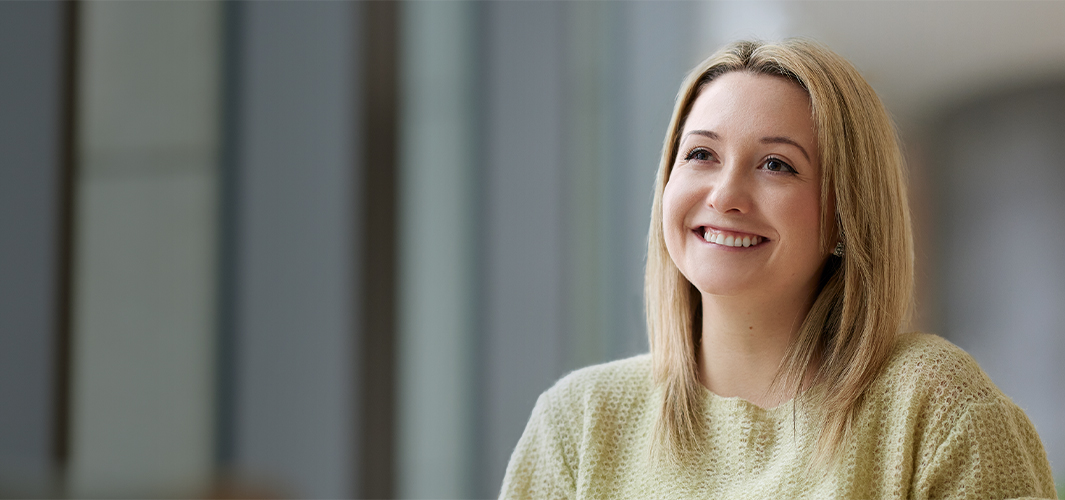 Georgia, assise, regarde vers la gauche en souriant.