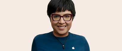 พนักงาน Apple Retail ที่มีผมสั้น สวมแว่น กำลังยิ้มให้กล้อง