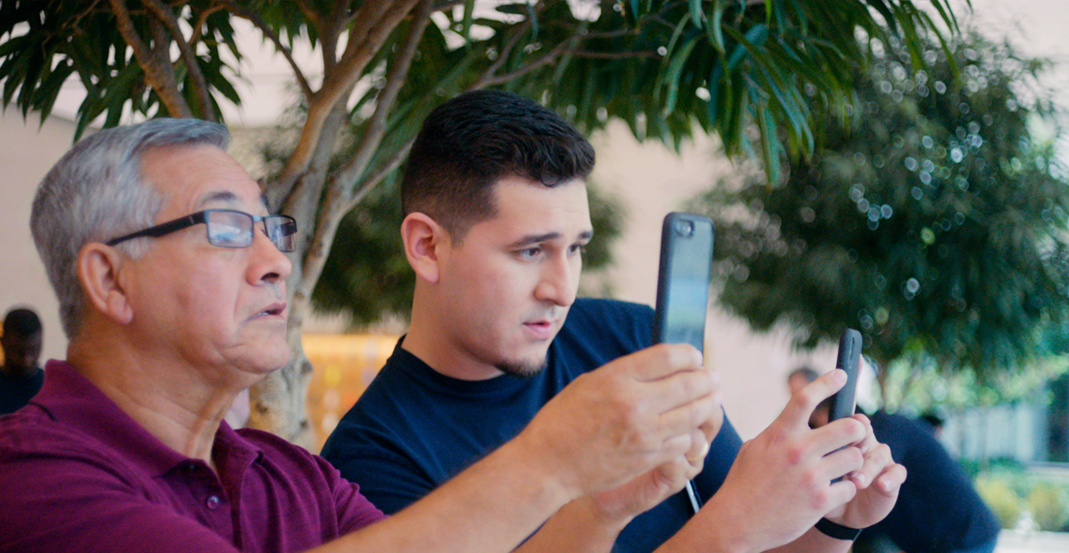 Jeronimo, som är Technical Specialist, visar en kund på Apple Store hur man använder kameran på iPhone.