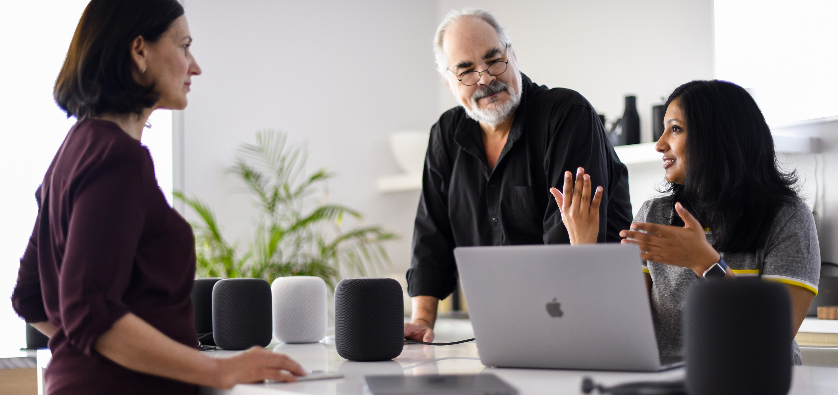 Un groupe d’employés d’Apple en apprentissage machine et en intelligence artificielle discutent dans un bureau.