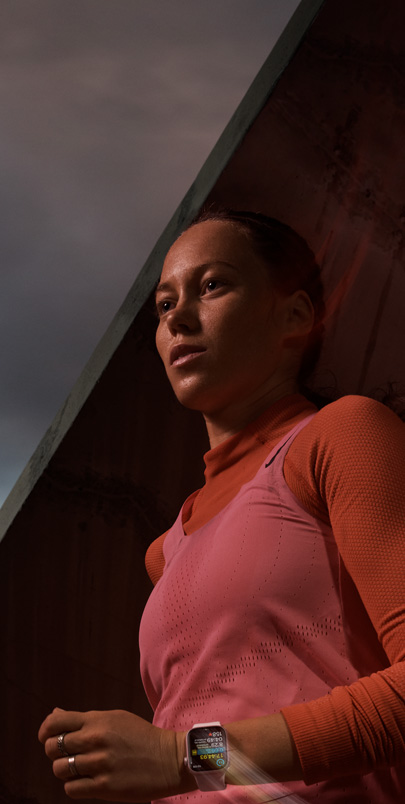 Una mujer usa un Apple Watch Series 9 que registra su entrenamiento mientras corre.