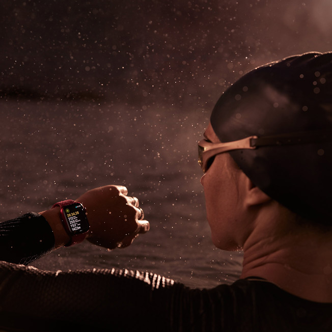 Ein Bild von einer Person, die in einem Swimmingpool schwimmt und auf ihre Apple Watch blickt.