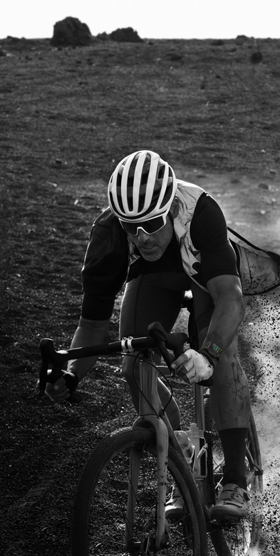 A man biking while wearing Apple Watch Ultra 2. Click the plus button to see more information on Apple Watch Ultra 2 features.