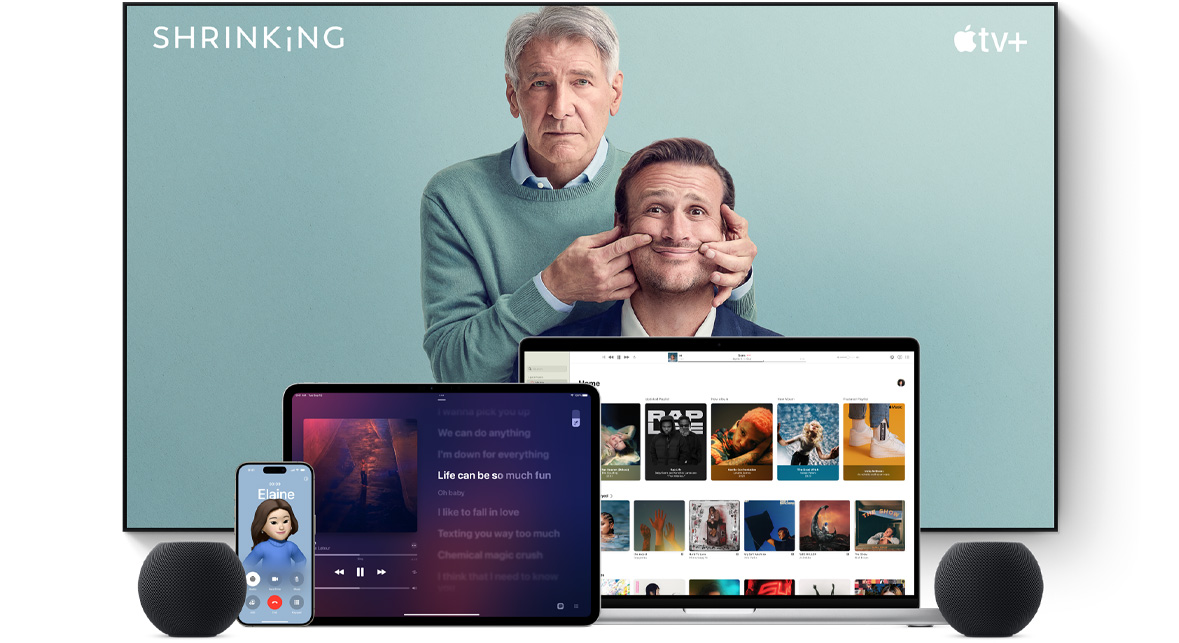 ทีวีจอแบนขนาดใหญ่แสดงตัวละครชายสองคนจากซีรีส์เรื่อง Shrinking ของ Apple TV+ โดยมี MacBook Pro, iPad, iPhone และ HomePod mini สีเทาสเปซเกรย์วางอยู่ด้านหน้า