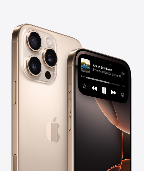 Beyaz Titanyum iPhone 16 Pro’nun, ekranında Dynamic Island görünen başka bir iPhone Pro’nun arkasında dururken üç kamera lensinin gösterildiği arkadan görünümü.