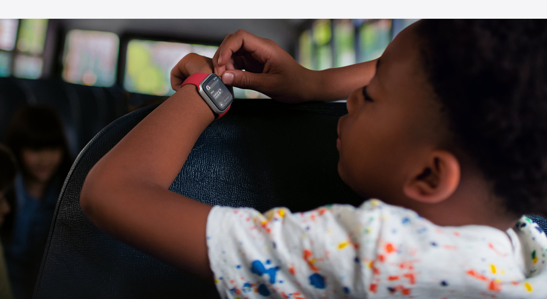 Illustration of two children’s hands and an adult hand holding an iPhone 16. Each child is wearing an Apple Watch SE. The adult hand is setting up Family Setup.