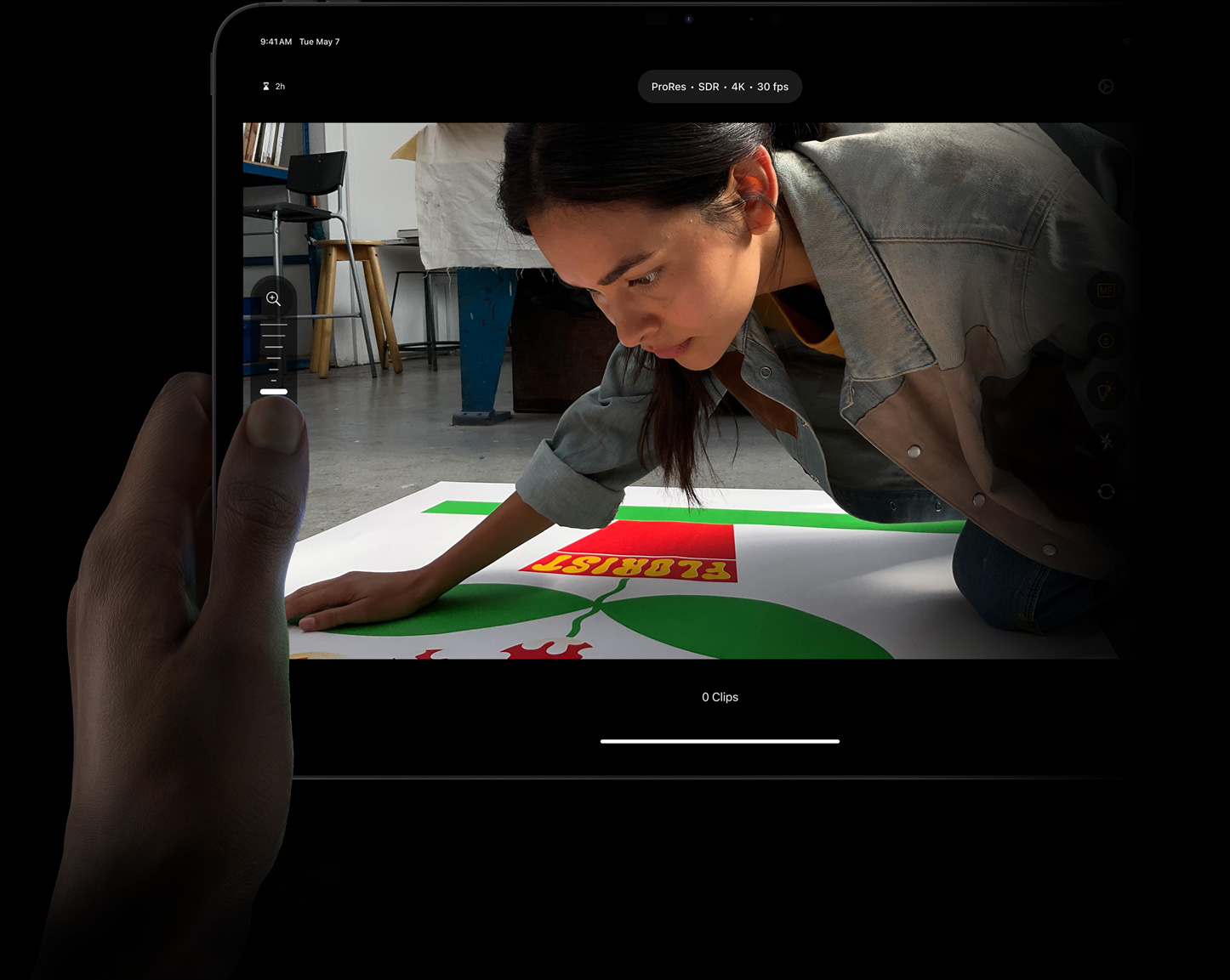 iPad Pro上のFinal Cut Proで、プロ仕様のカメラモードでマニュアルコントロールを使いながら、ProResビデオのフォーカスを親指で調整している。