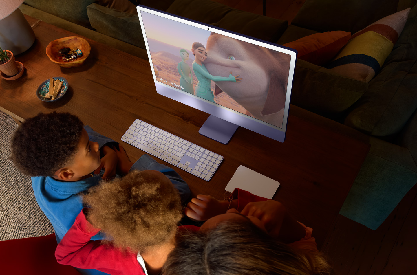 Drei Kinder sehen sich die Serie WondLa auf einem iMac an