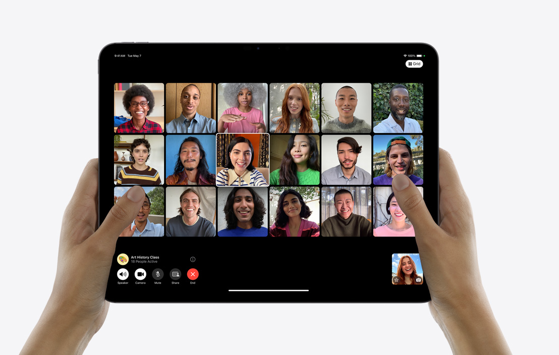 Две ръце, държащи iPad Pro, на който се вижда групов разговор във FaceTime.