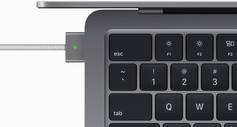 Ülaltvaade, kus on näha MagSafe kaabliga ühendatud MacBook Air toonis kosmosehall