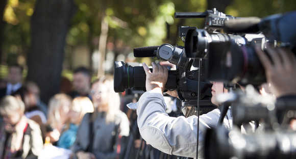 Fernsehkameras sowie Journalistinnen und Journalisten bei einer Pressekonferenz im Freien.