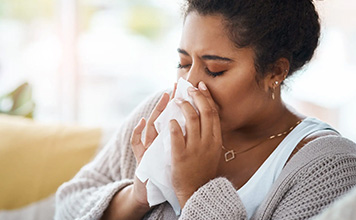 A woman blows her nose. Medicare and private insurance protect you.