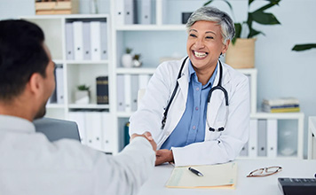 A doctor shakes a patient's hand. 