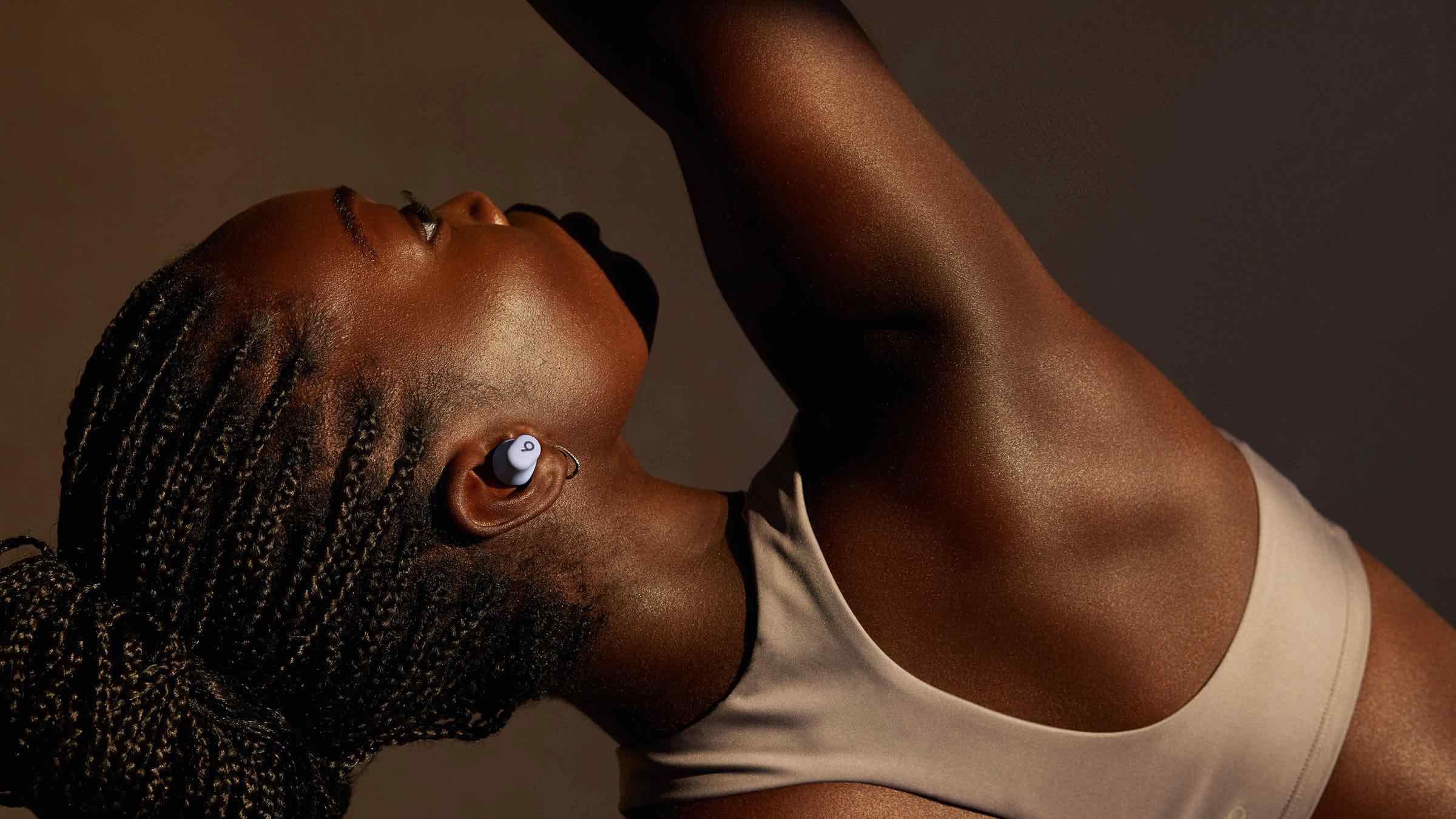 Woman stretching while wearing Beats Solo Buds.