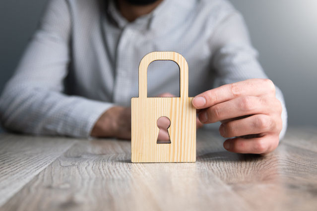 ein Schloss in Holzoptik wird von einer Hand gehalten (verweist auf: Die Grundlagen des Datenschutzrechts)