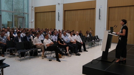 Staatssekretärin Bender steht auf auf der Bühne am Rednerpult, vor Ihr sitzend die Konferenzteilnehmer