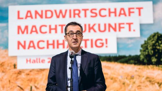 Bundesminister Cem Özdemir in der Halle des BMEL auf der  Internationalen Grünen Woche 2023. Im Hintergrund das Motto: Landwirtschaft macht Zukunft. Nachhaltig!