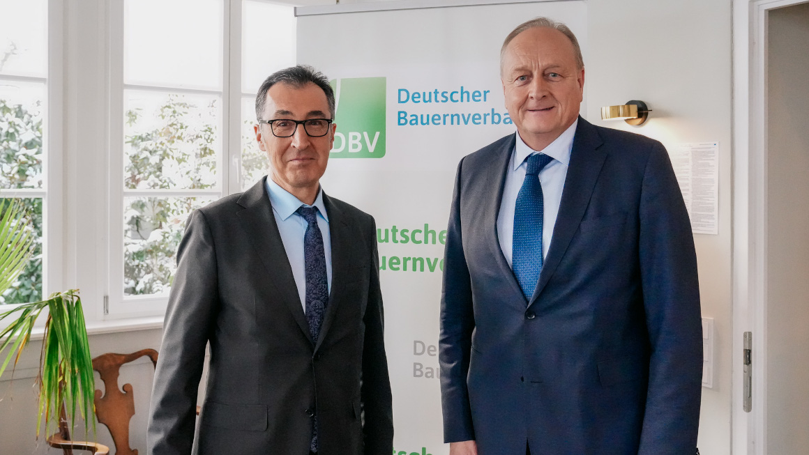 Bundesminister Özdemir und der Präsident des Deutschen Bauernverbandes Rukwied schauen in die Kamera.